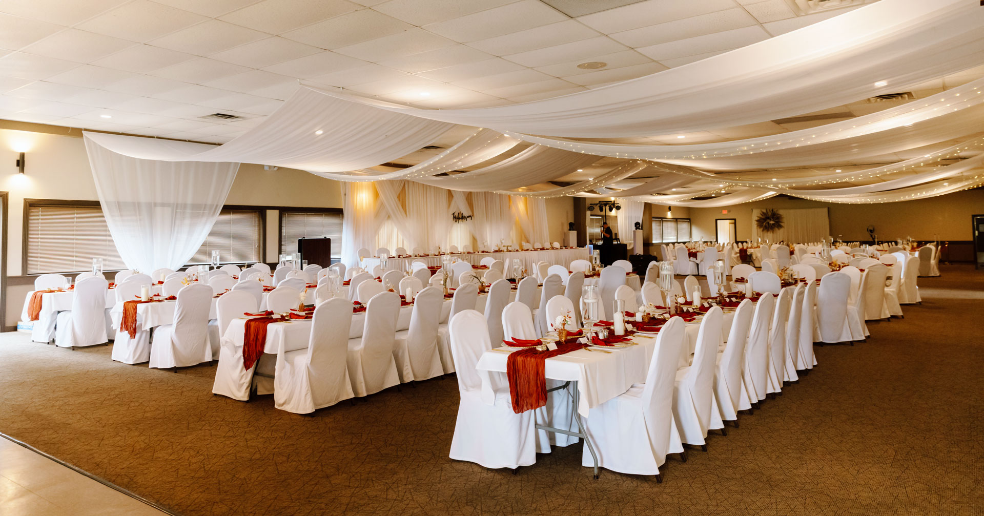 Elegant banquet hall with rows of decorated tables and chairs