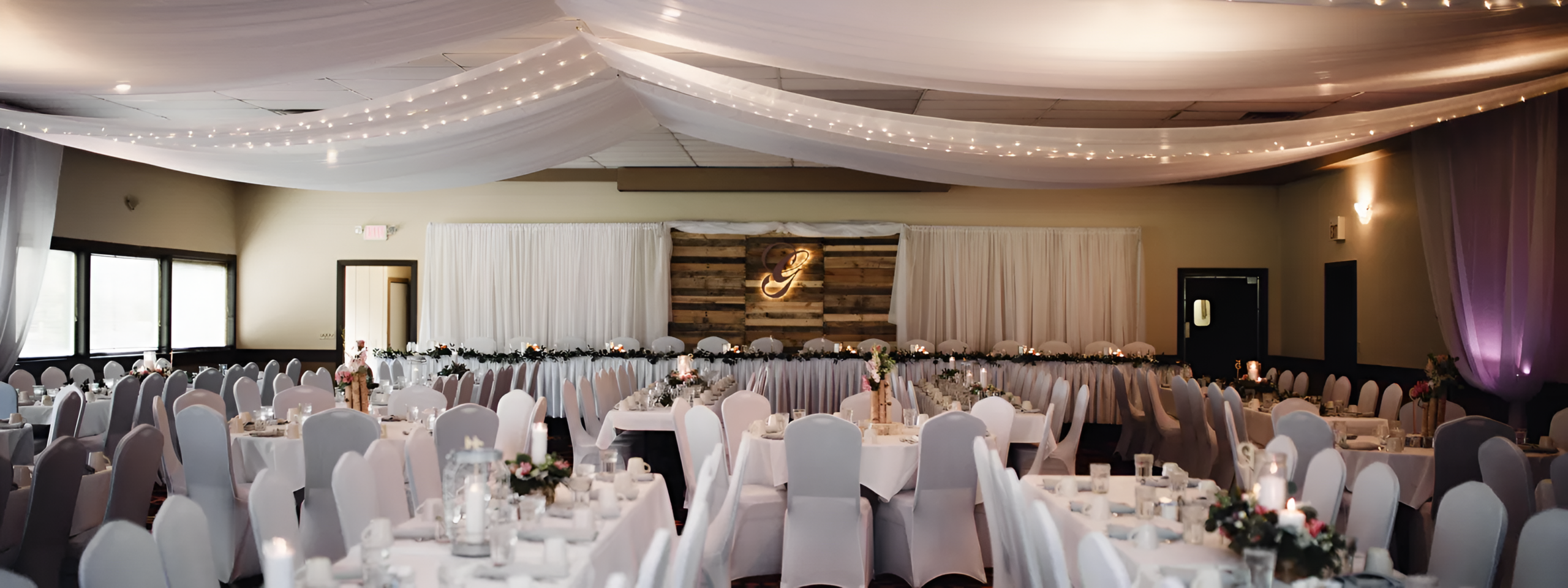 Elegant banquet hall with rows of decorated tables and chairs