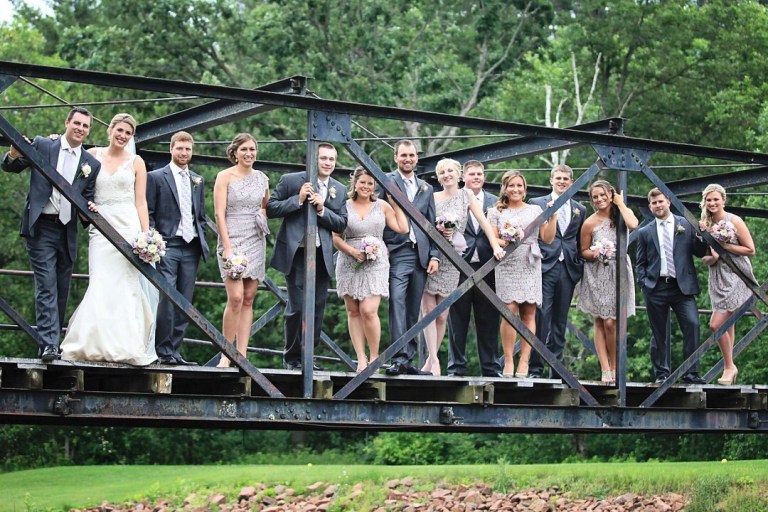 Bridal party posing on a metal bridge